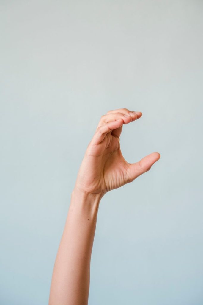 A delicate hand gesture captured with a light blue background, perfect for design and communication concepts.